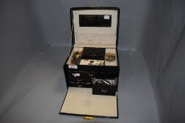 A travel jewellery case containing a small selection of costume jewellery including pendants,