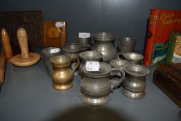 A selection of small size pewter tankards and measures