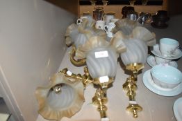 Four brass wall mounted lights with matching glass shades