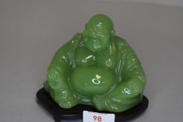 A green figure of a seated Buddha