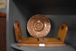 An arts and crafts copper bowl and a wooden oak book stand