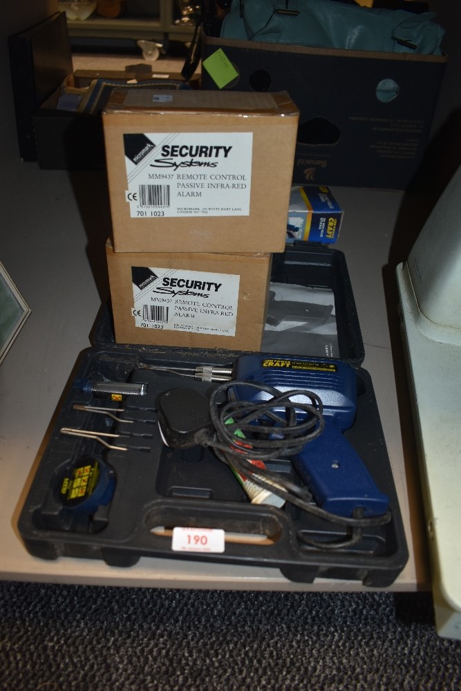 A modern soldering gun and two security alarms