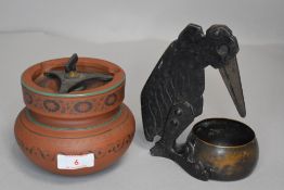 An antique terracotta tobacco jar and a cigar cutter in the for of a crow