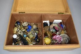 A treen box containing a selection of earrings of various forms