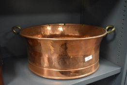 A large twin handled copper bowl in good condition