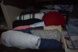 A collection of ladies knitwear and scarves.