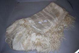 A antique cream silk shawl having deep fringing to edges.