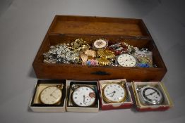 A treen box containg a selection of costume jewellery and pocket watches including Ingersoll