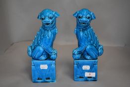 A pair of Chinese hard paste dogs of fo or foo having blue azure glaze