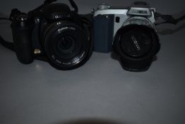 A Minolta digital camera and a Freepix HS10 digital camera in soft carry bags