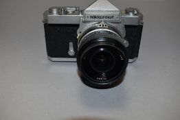 A Nikkormat FT camera with Nikkor 35mm lens in original leather cover