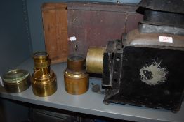 A magic lantern in wooden box with brass lenses (one lens cracked)