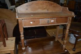 A reproduction pine washstand in the Victorian style having ledge back and turned legs
