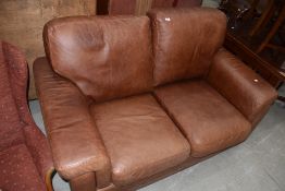 A modern tan leather two seat settee