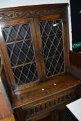 A late C20th oak Jacobean style full height cupboard, having leaded glass top with drawers and