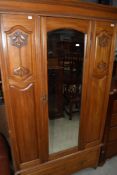 A late Victorian satinwood single wardrobe, having mirror door and drawer under, w 107cm