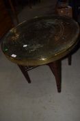 An early C20th circular brass top Eastern table on folding wood stand