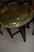 Am early C20th circular brass top Eastern table having folding wood stand