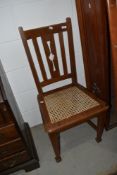 An early 20th Century stained frame chair having bergere seat