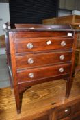 An early 20th mahogany music cabinet having fall fronts on slender legs, w 53cm