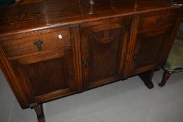 A 1930's oak sideboard, having cupboards and drawers, on shaped base, w 137cm