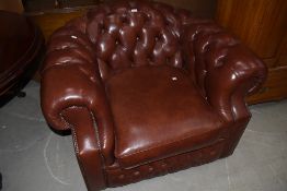 An modern English brown leather upholstered button back armchair