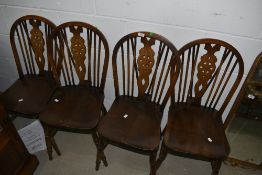 A set of four late C20th stained frame wheel back dining chairs