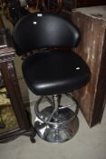 A modern chrome and black vinyl upholsterd kitchen/bar stool