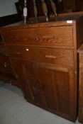 A vintage oak tall boy chest with two shallow drawers over double cupboard