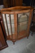 A 1930's walnut demi lune display cabinet, having silvered glass decoration, and cabriole legs,