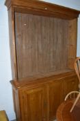 A traditional pine bookcase, triple cupboard under having Victorian style brass handles, glazed