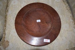 A turned wood plate, possibly from a lazy susan