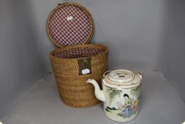 An unusual vintage hand painted oriental tea pot in padded basket.