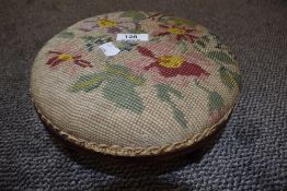 A wood framed late 19th/early 20th century needlepoint foot stool.