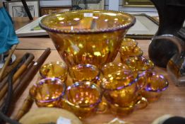 A large 1930s Bubble glass punch bowl and eleven matching cups, in iridescent orange having fruit