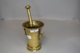 An antique brass pestle and mortar.