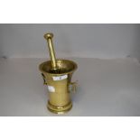 An antique brass pestle and mortar.