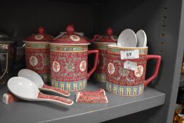 A collection of Chinese ceramics including lidded mugs, tea pot and spoons.