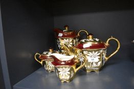 A richly gilded partial tea and coffee set by Sadler having burgundy ground and daisy pattern.