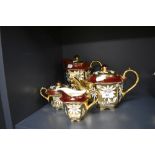 A richly gilded partial tea and coffee set by Sadler having burgundy ground and daisy pattern.