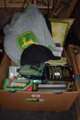 A box of John Deere collectables including tee shirts, hats and boxed toys.