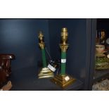A pair of vintage brass columned table lamps having painted green stems.