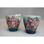 Two vintage Moorcroft beakers having green ground and clematis pattern in pink.
