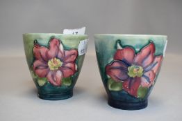 Two vintage Moorcroft beakers having green ground and clematis pattern in pink.