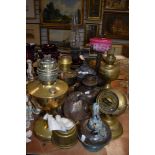 A selection of antique oil lamps and useful parts, one having cranberry glass reservoir and