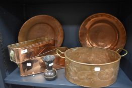 An assortment of copper planters with handles, plates and a vase.