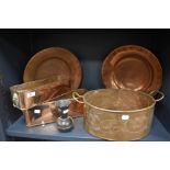 An assortment of copper planters with handles, plates and a vase.