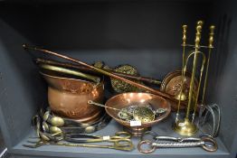 A copper coal helmet, a brass fireside companion set, horse brasses,bellows and more.