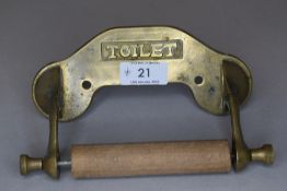 A Vintage brass and wood toilet roll holder.