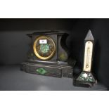 An antique black marble mantel clock having green stone inset details and etched designs, brass